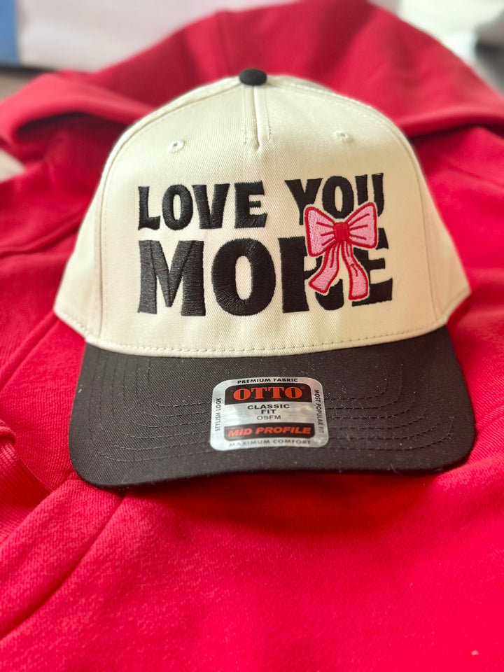 Love You More embroidered hat with a pink bow.