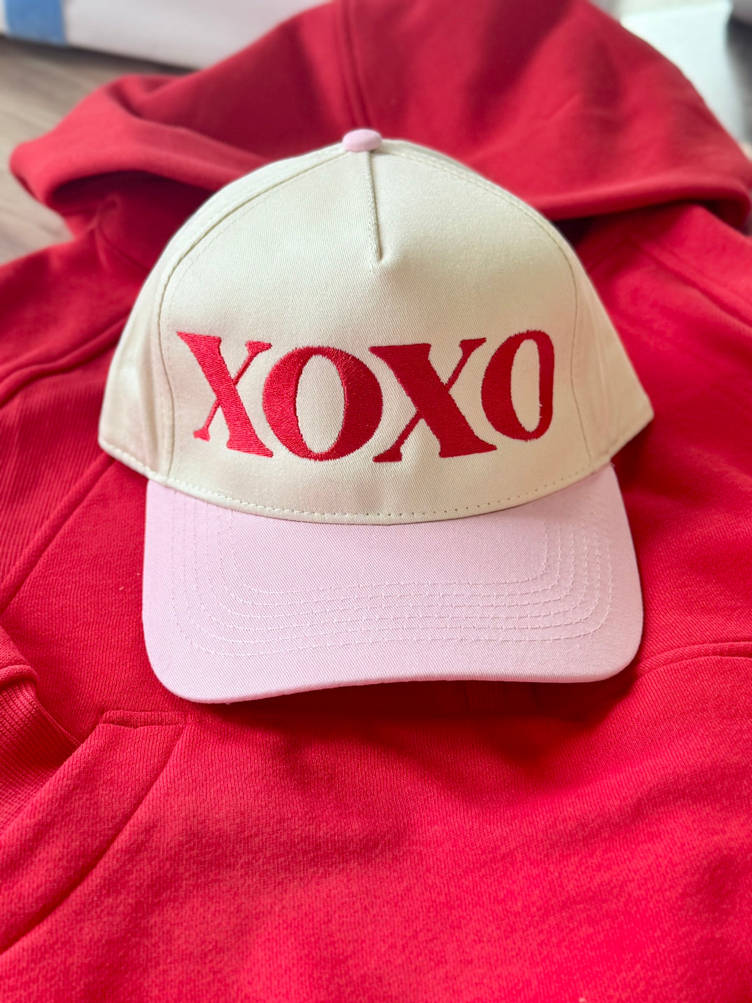 XOXO embroidered hat with a cream crown and pink brim.