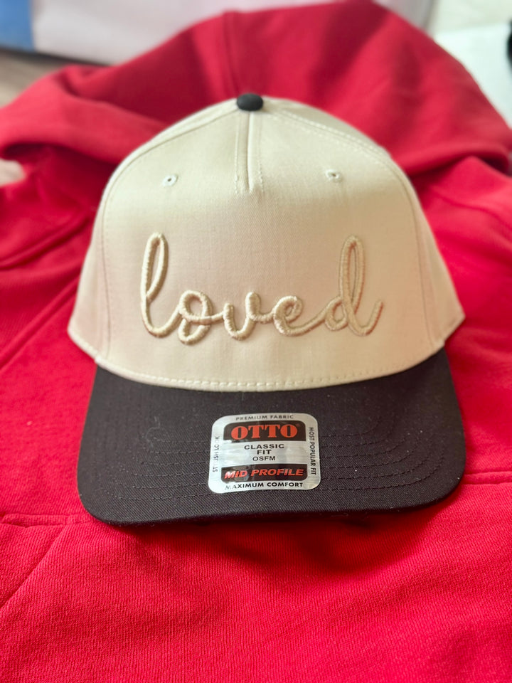 Loved embroidered hat with tan crown and black bill.