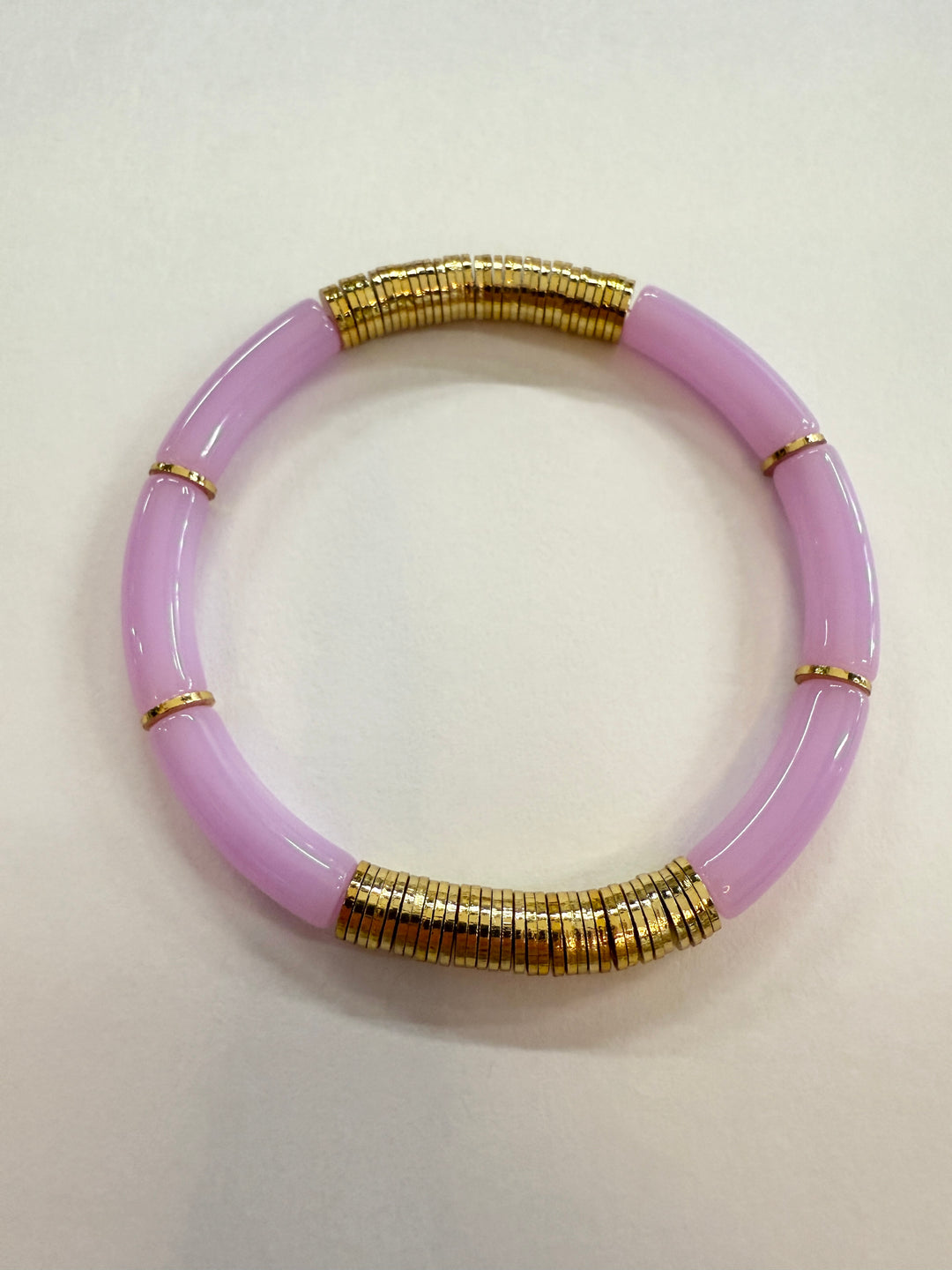 A light purple noodle bracelet with gold-plated disc beads.