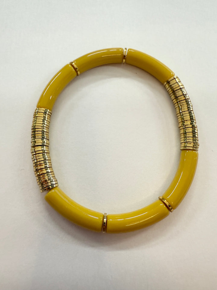 A yellow noodle bracelet with gold-plated disc beads.