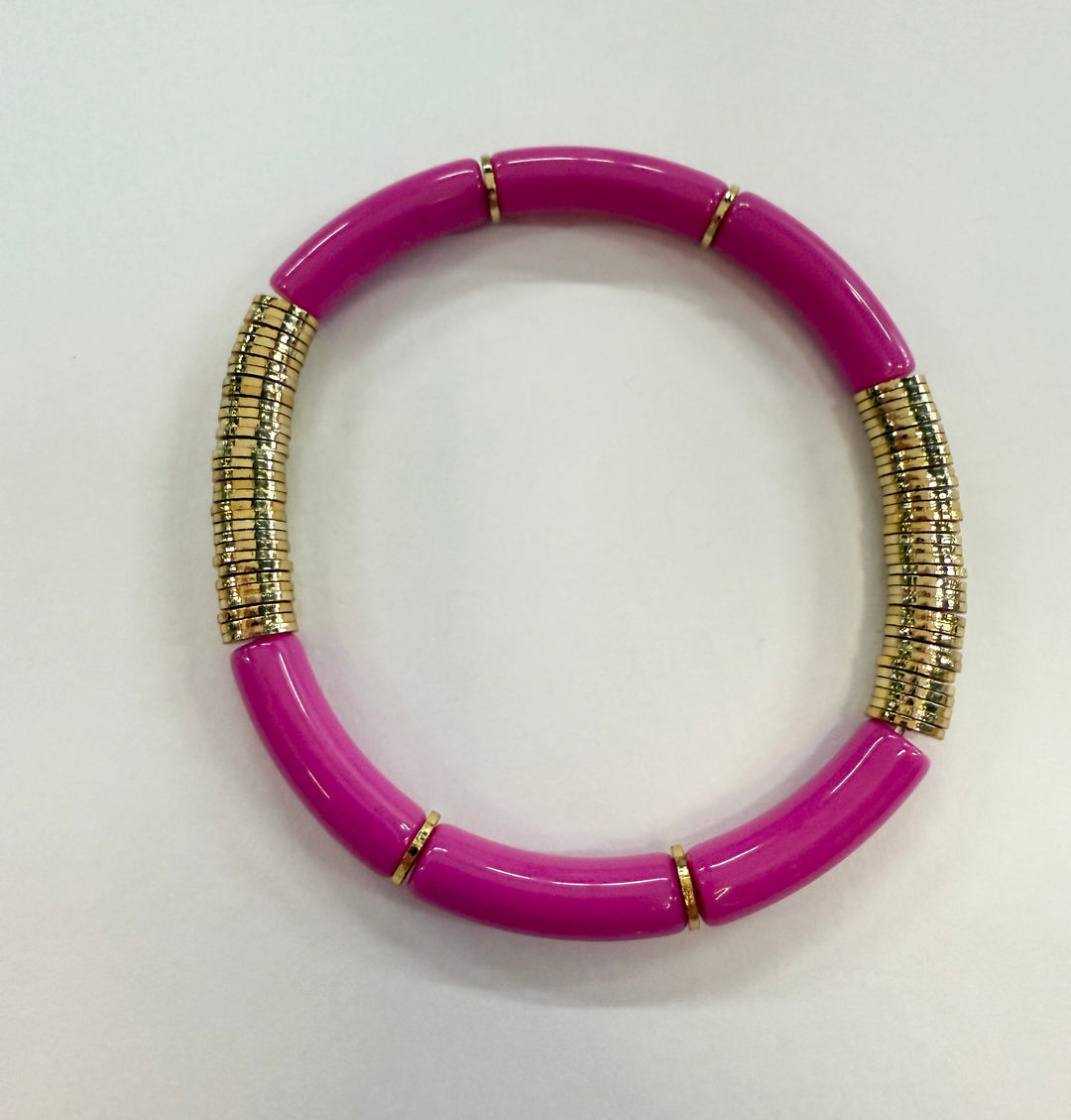A magenta noodle bracelet with gold disc beads.