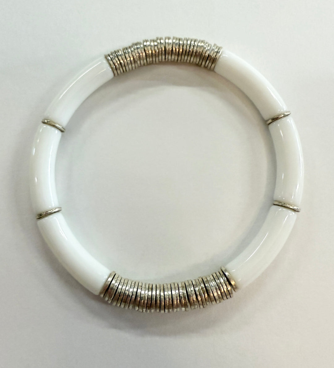 White noodle bracelet with silver-plated disc beads.