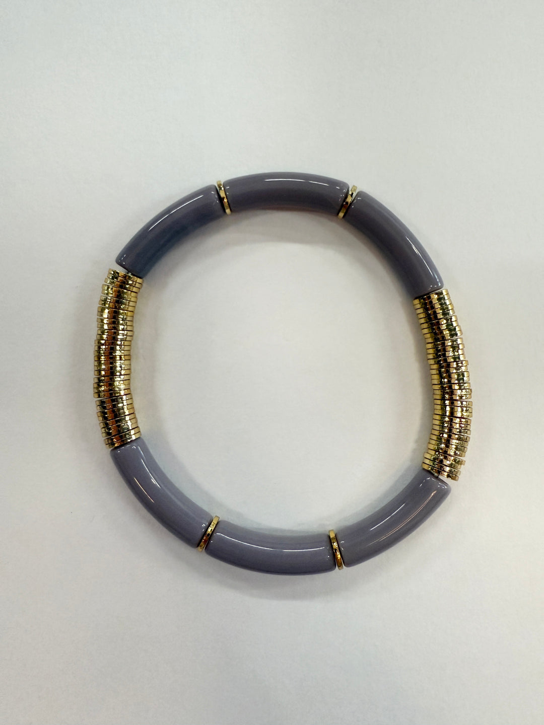 A gray noodle bracelet with gold disc beads.