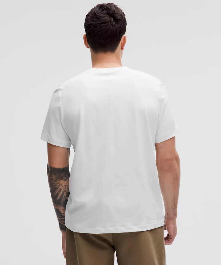 Back view of a man wearing a white short-sleeve t-shirt.