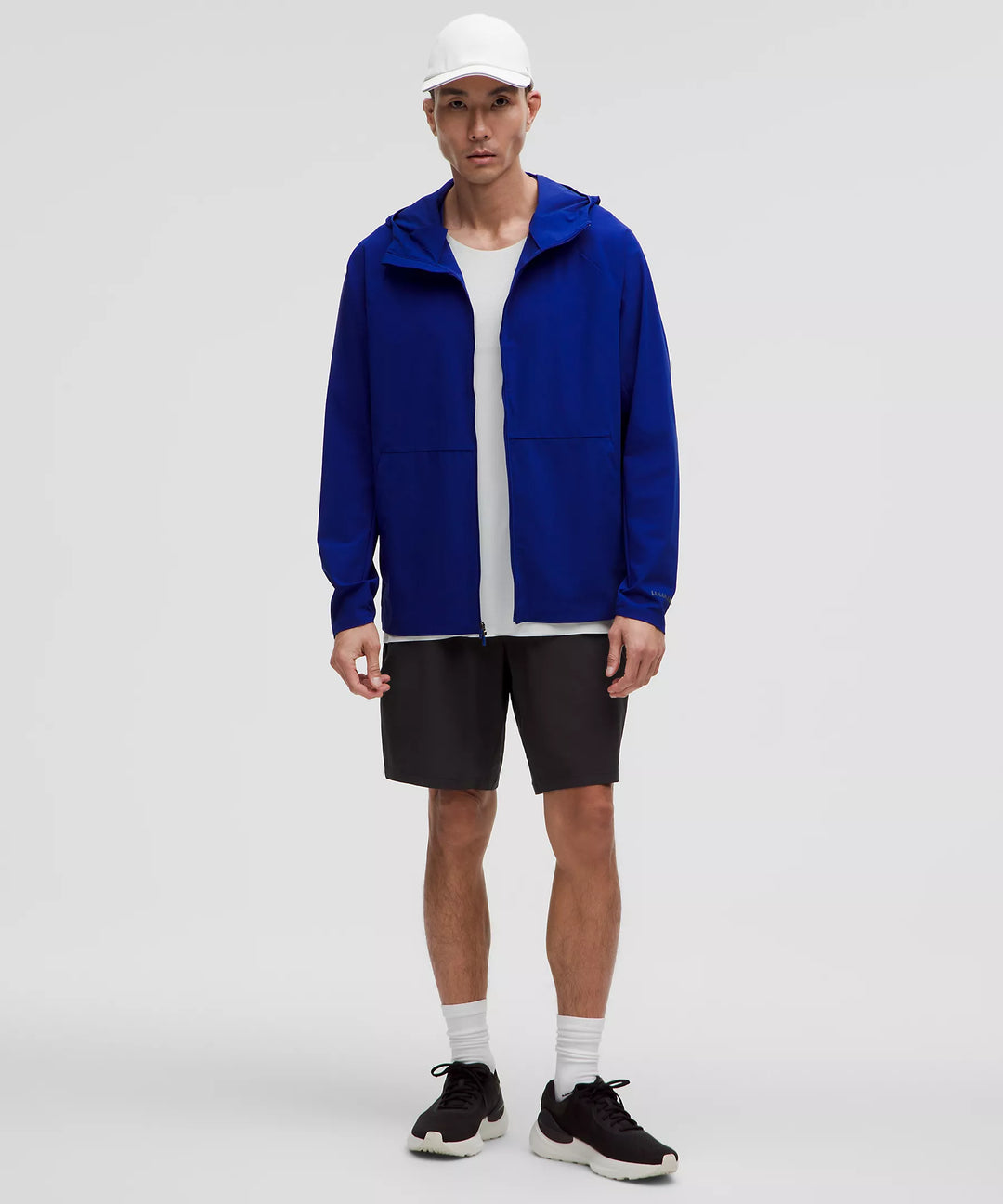 Men in black shorts, a blue jacket, and a white cap.