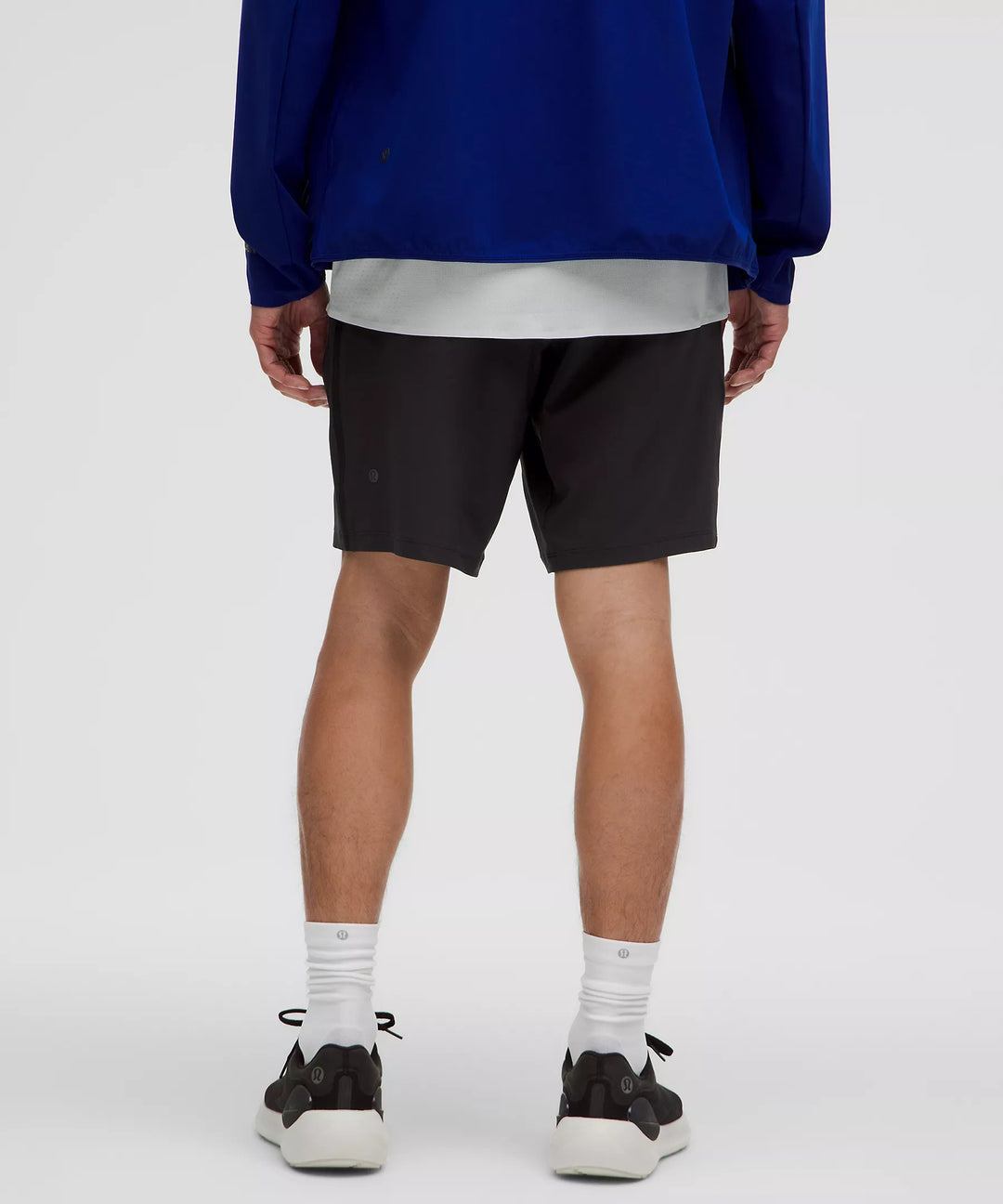 Men's black Pace Breaker Linerless Short 7" with white socks and black sneakers.