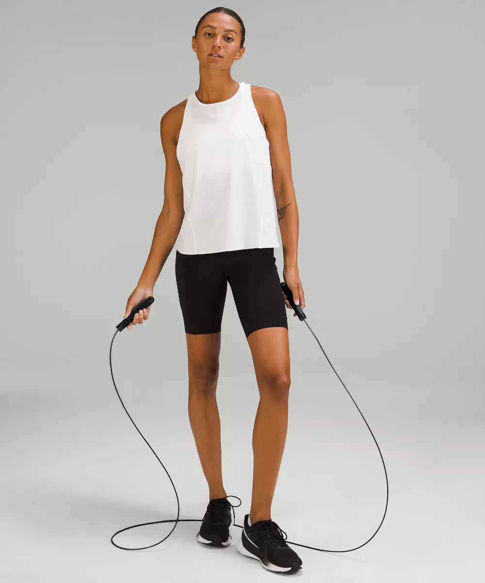 A woman in athletic wear holds a jump rope.