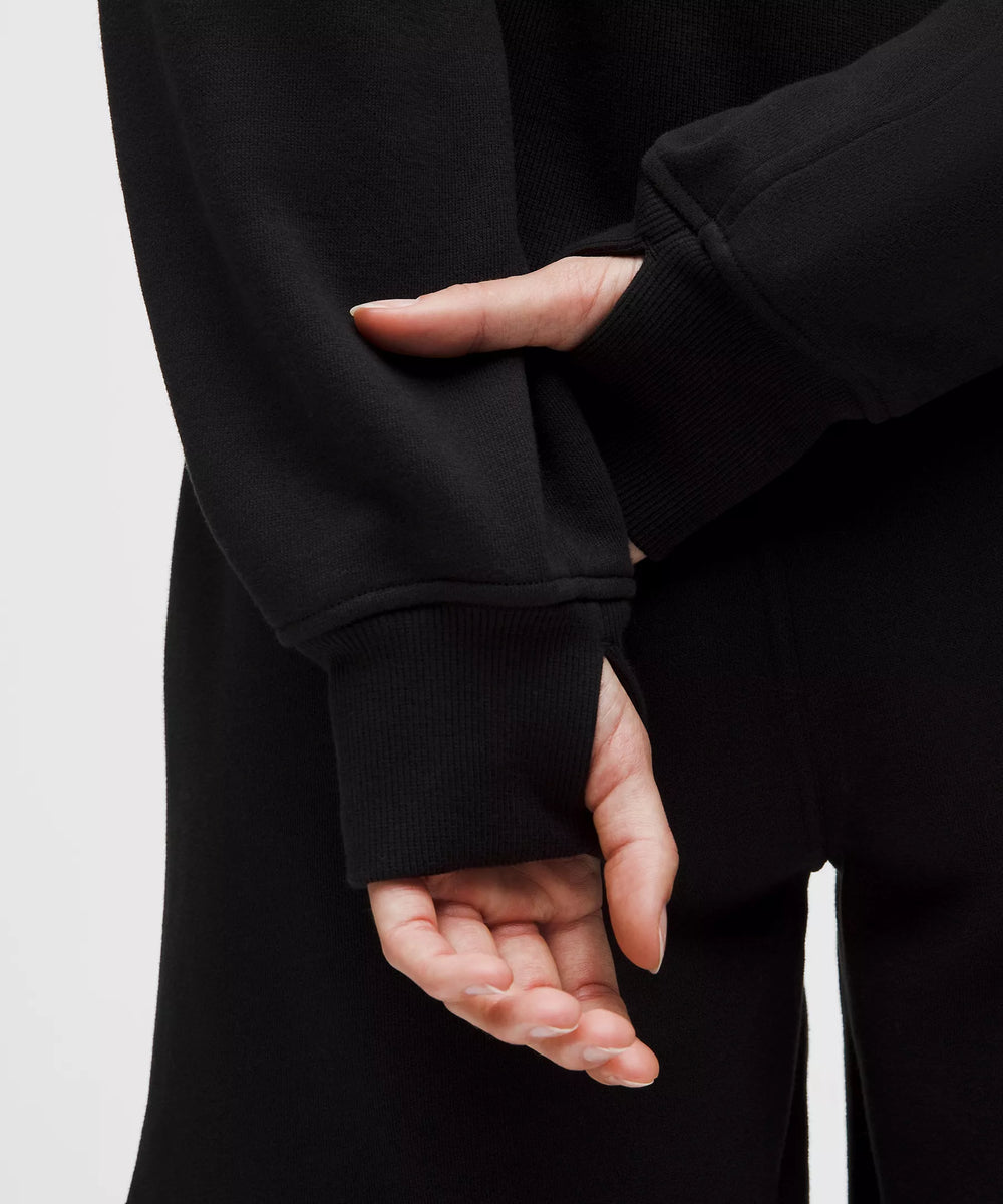 Black oversized full-zip hoodie with thumbholes and ribbed cuffs.