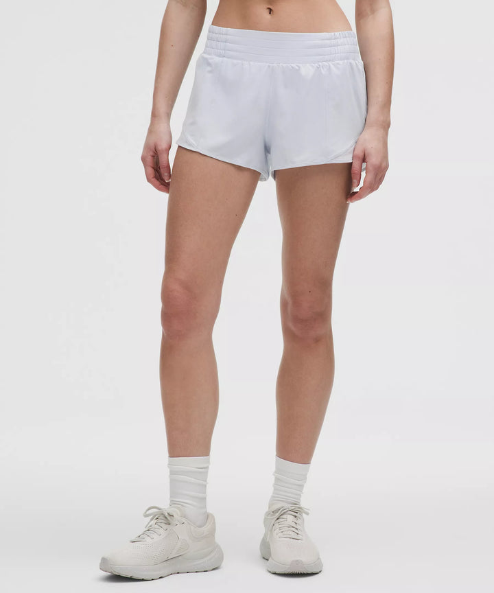 A person wears light blue running shorts, white socks, and white athletic shoes.