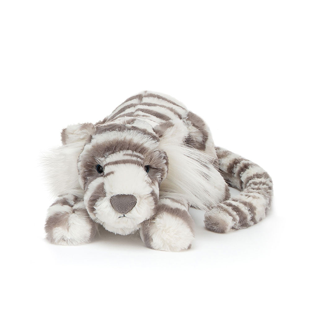 A plush snow tiger with grey and white stripes lies facing forward.