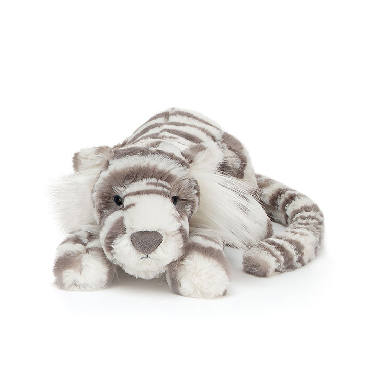 A plush snow tiger with grey and white stripes lies facing forward.