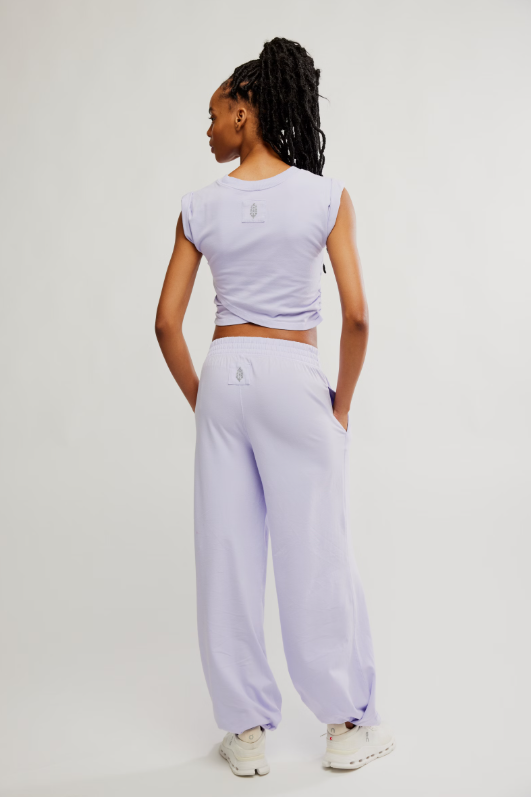 A woman from behind wears a light purple cropped top and matching sweatpants.