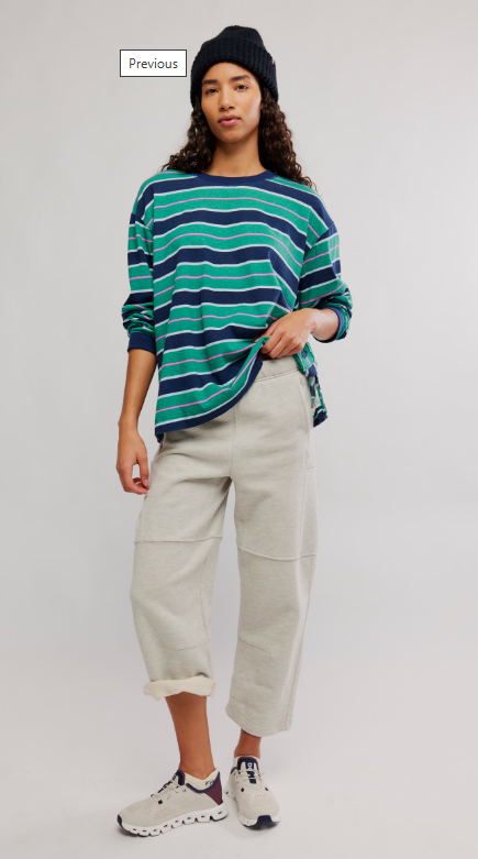 Woman wearing a navy and green striped long-sleeve shirt and light grey pants.