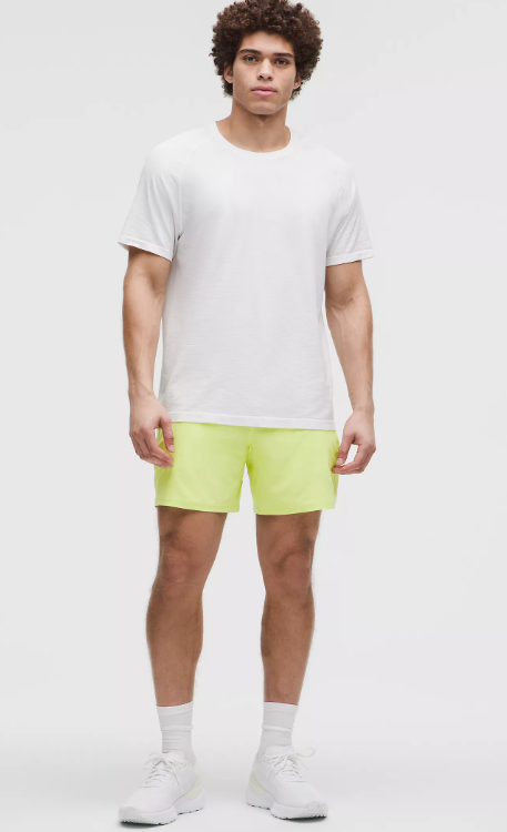 Men's white t-shirt and lime green athletic shorts.