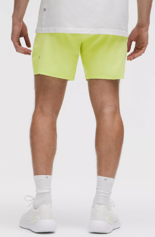 Men's 7" lime green athletic shorts with white socks and shoes.
