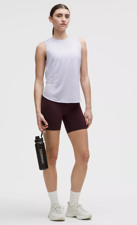 A woman holds a black Lululemon water bottle.