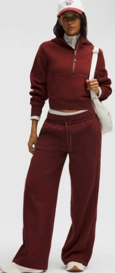 A woman wears a maroon oversized half-zip hoodie and matching wide-leg sweatpants.