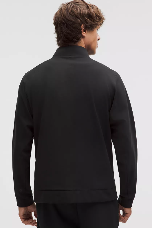 Back view of a man wearing a black Sojourn Jacket.