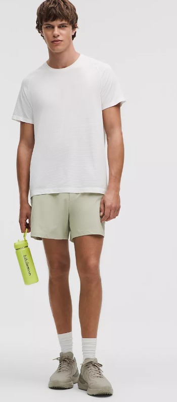 Men's green athletic shorts with a white t-shirt and water bottle.