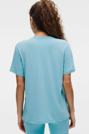 Washed blue jersey training short sleeve shirt worn from the back.