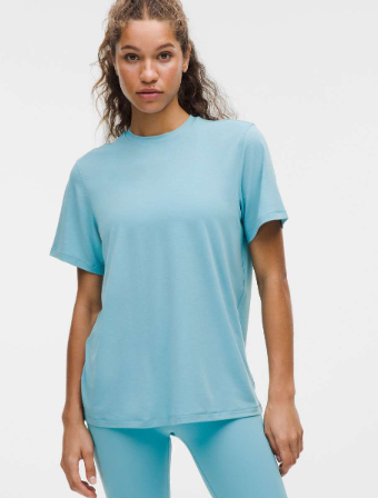 A woman wears a washed blue, short-sleeve jersey training shirt.