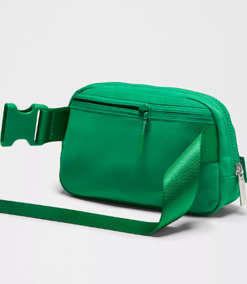 Green belt bag with adjustable strap and zippered pocket.
