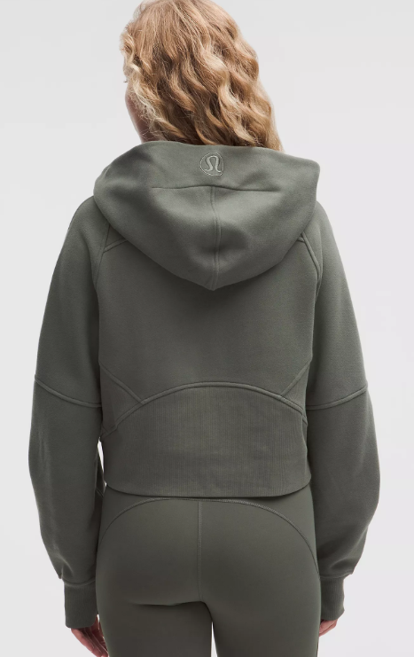 Back view of a woman wearing an oversized, cropped, olive green Lululemon hoodie.