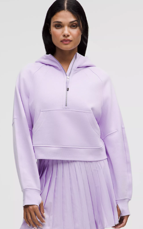 A woman wears a lavender frost scuba oversized half-zip hoodie.
