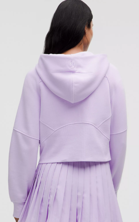 Back view of a lavender oversized cropped hoodie with a pleated skirt.