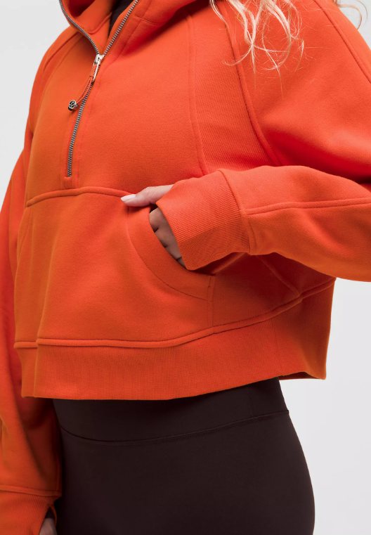 An orange oversized half-zip hoodie with a kangaroo pocket.