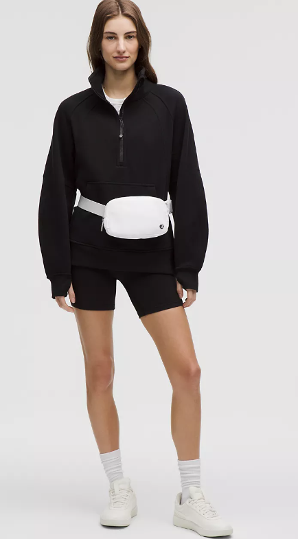 White Everywhere Belt Bag worn by a woman in athletic wear.