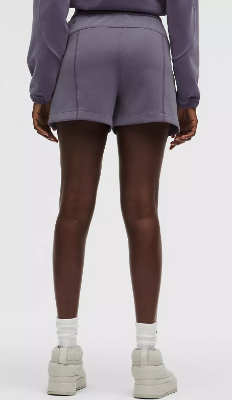 A person wearing purple Softstreme high-rise shorts and white socks.