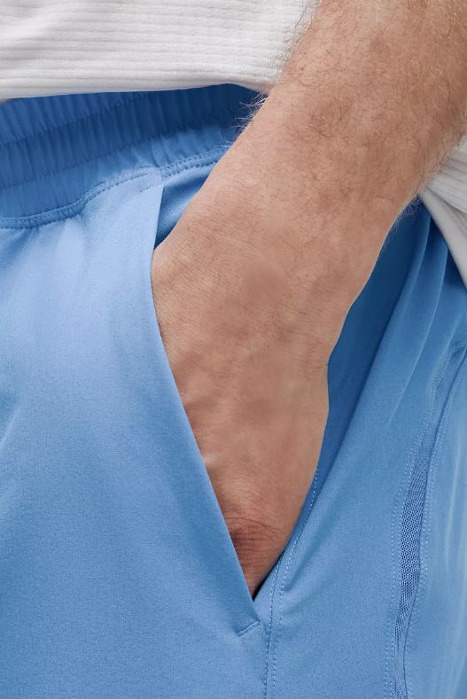 Men's blue Pace Breaker Linerless Shorts with a hand in the pocket.