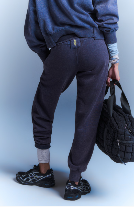 Dark navy sweatpants with a gold logo detail on the back pocket.