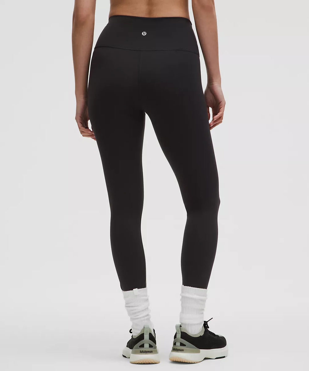 Black Wunder Train high-rise 25" tights with white socks and sneakers.