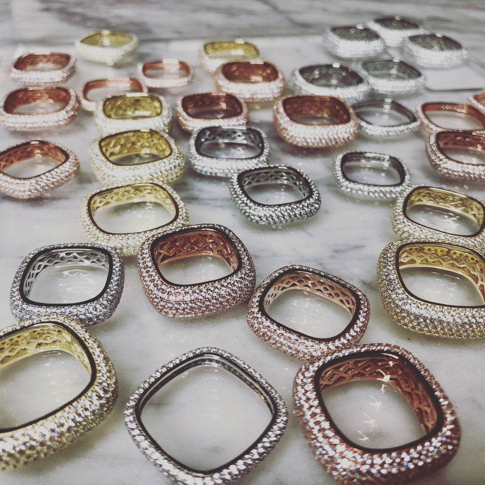 Thin pave rings in gold, rose gold, and silver are displayed on a white surface.
