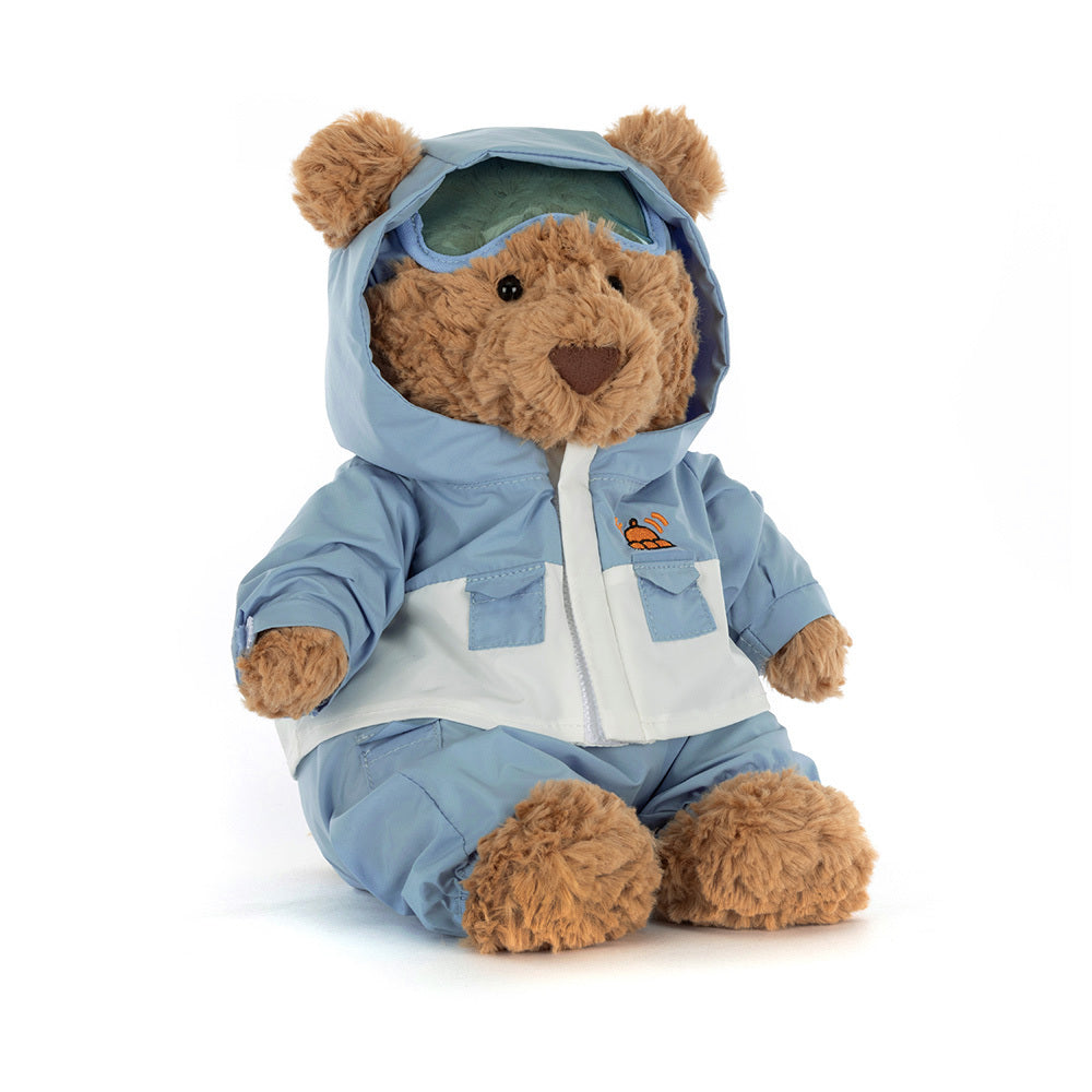 A brown teddy bear wearing a light blue and white snowsuit with goggles.