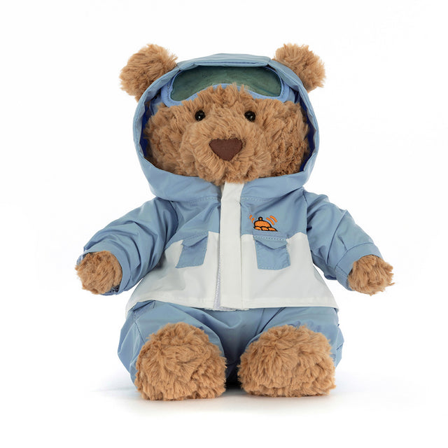 A plush brown bear wearing a light blue and white snowsuit with goggles.