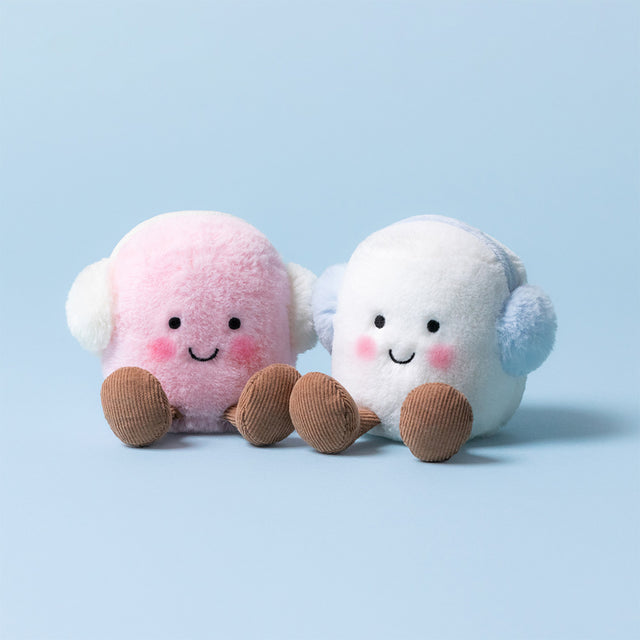 Two plush marshmallows, one pink and one white, wearing earmuffs, sit side by side.