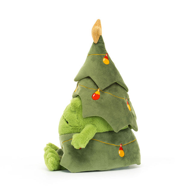 A plush green frog peeks out from a Christmas tree costume adorned with colorful baubles.