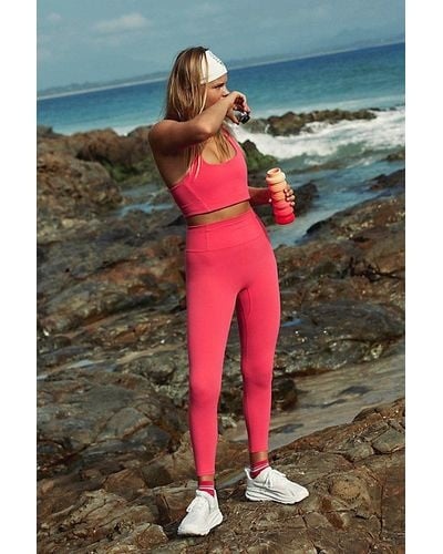 Never Better Leggings in Electric Sunset, worn by a woman with a matching sports bra.