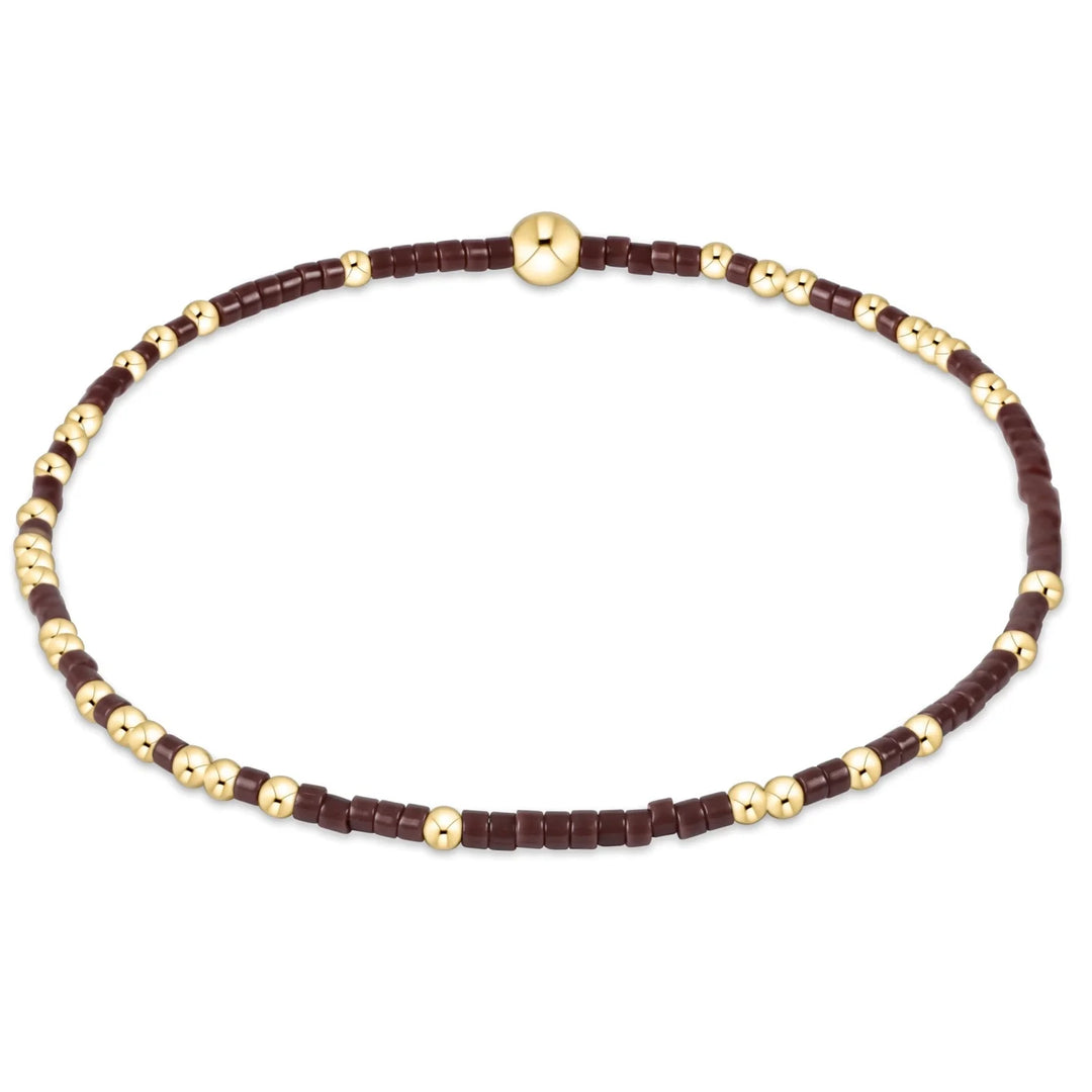 Chocolate brown square beads and gold round beads form a bracelet.