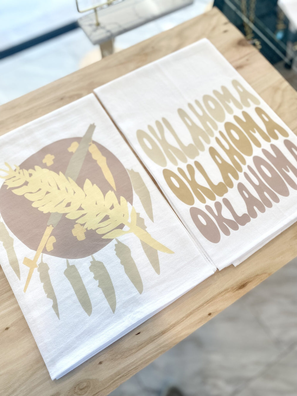 Two white tea towels, one with "Oklahoma" text and one with a wheat and chili design.