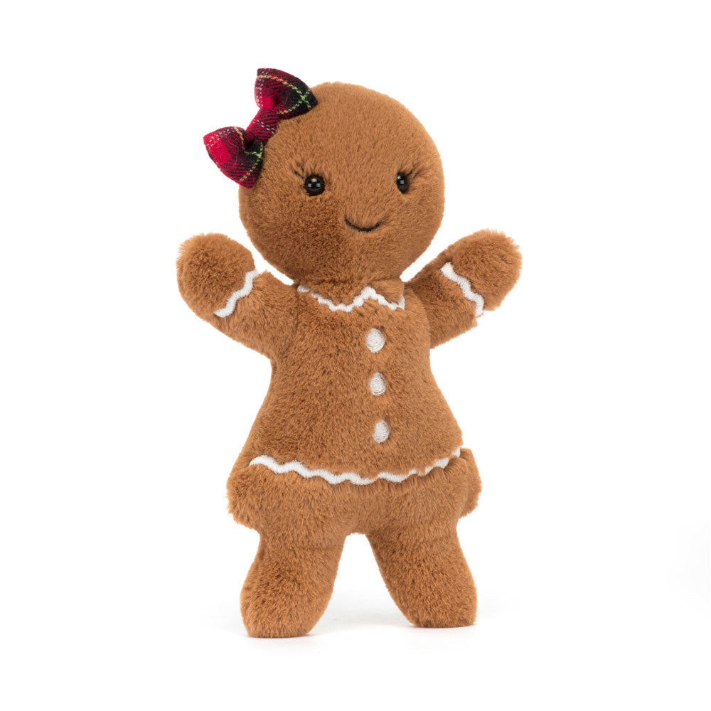 A plush gingerbread doll with a red tartan bow and white icing details.