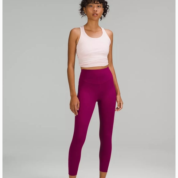 A woman models high-rise 25" leggings in wildberry.