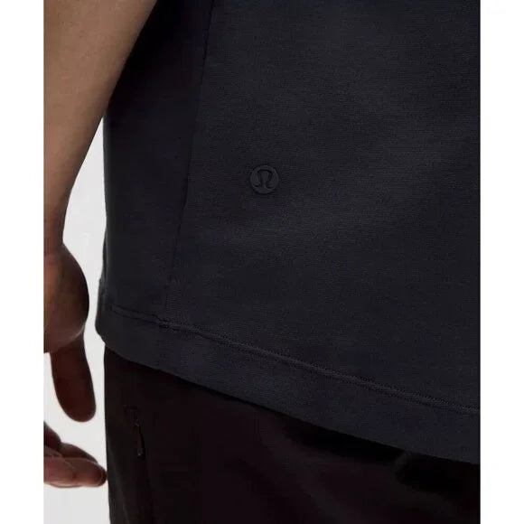 Close-up of a navy blue Lululemon short-sleeve polo shirt with a logo.