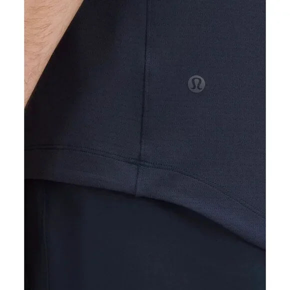 Close-up of a navy blue Lululemon short-sleeve shirt with a logo.