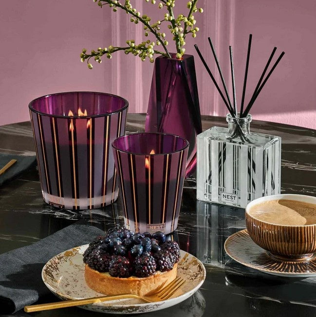 Autumn Plum Classic Candle in a striped purple glass vessel.