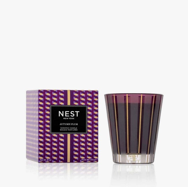Autumn Plum Classic Candle in a purple striped box next to a matching glass candle.